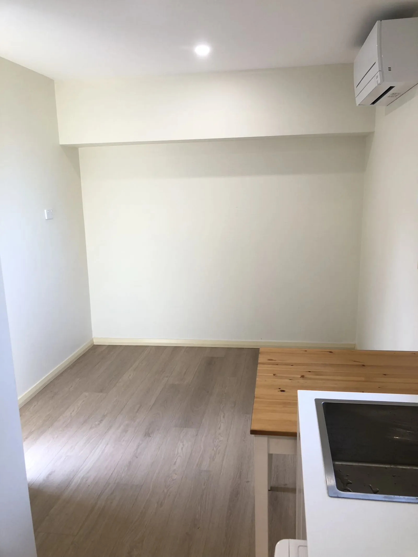 Completed Eastwood kitchen and adjoining space with timber flooring, painted walls and a section of benchtop