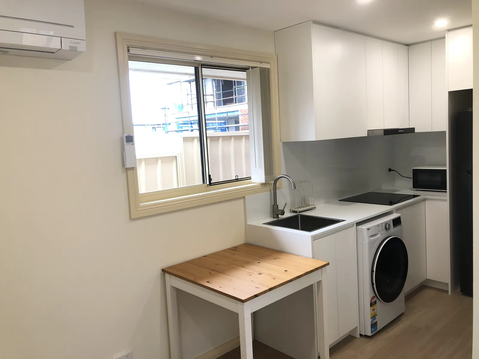 Completed compact Eastwood kitchen and laundry with white cabinetry